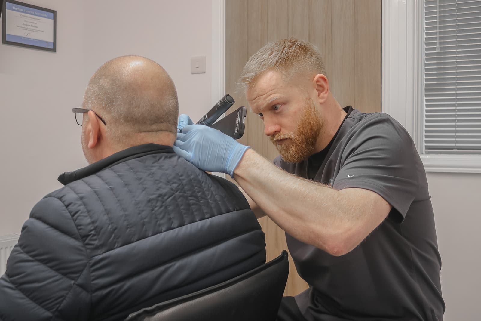 Audiologist performing microsuction ear wax removal
