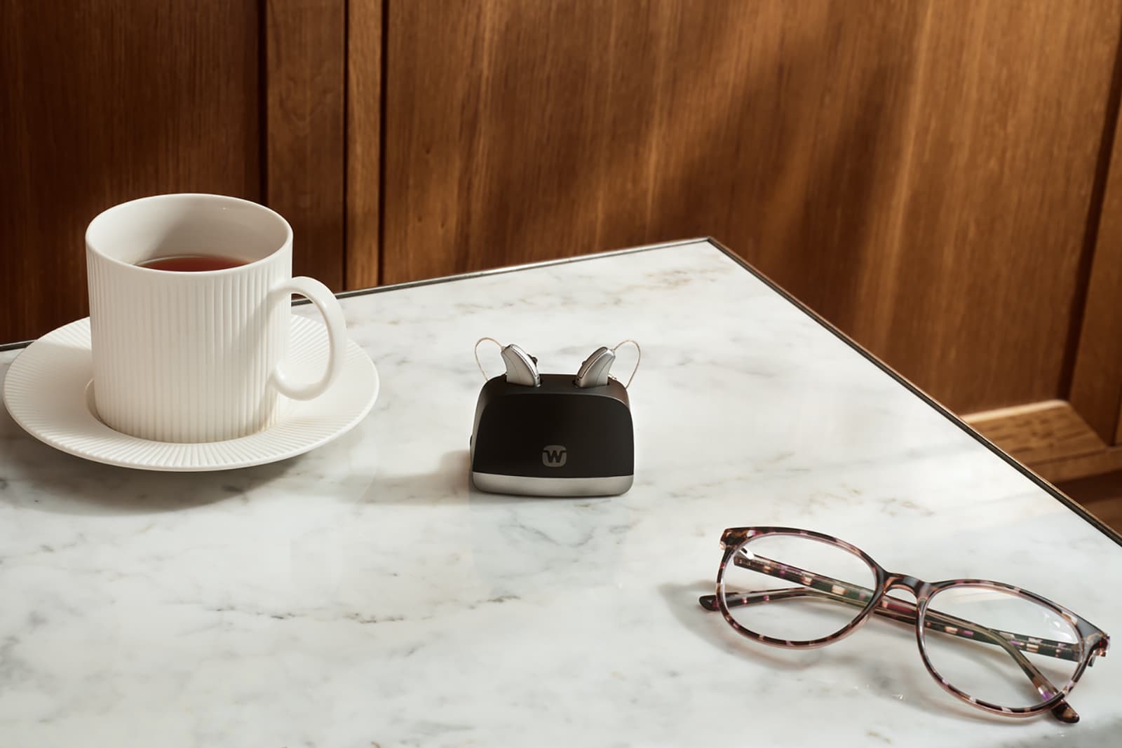 Widex Allure RIC hearing aids in their charger