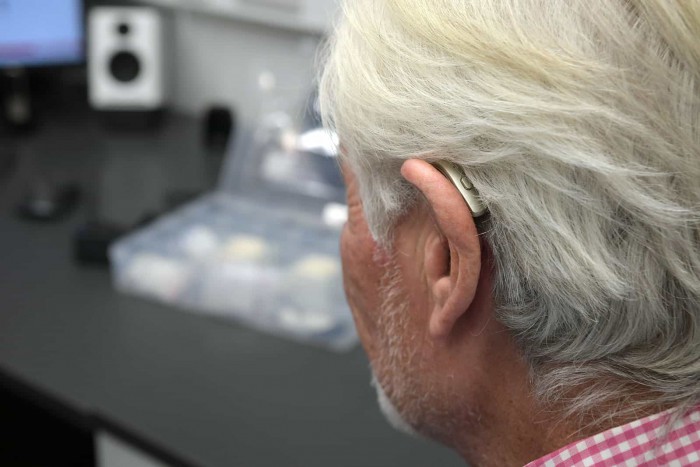 Man's ear showing his hearing aid from behind