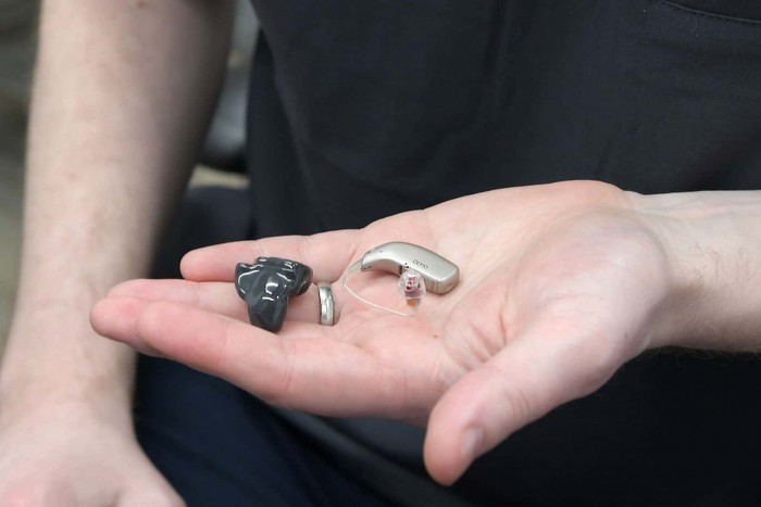 Audiologist holding Resound Omnia Receiver in the Canal and Custom Rechargeable Hearing Aids