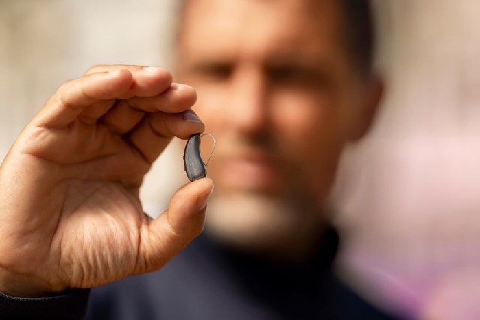 Man holding Signia IX hearing aid
