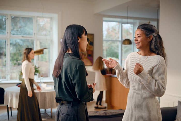 Woman chatting at a party wearing Widex Allure RIC hearing aids