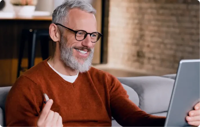 man showing his hearing aid using an iPad