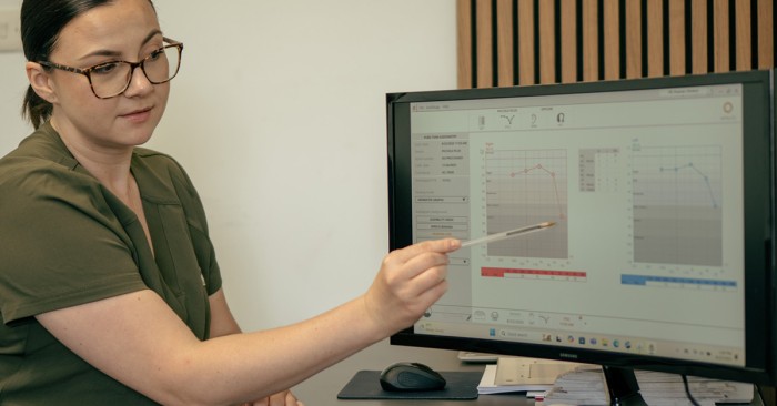 lady explaining hearing test results on a computer