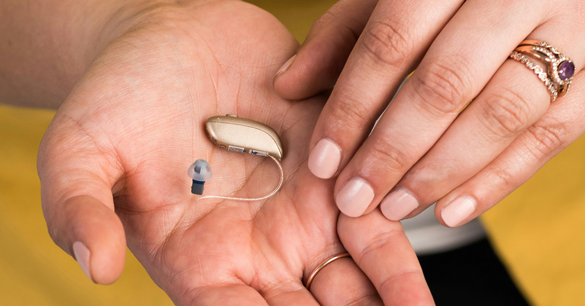Resound Omnia Hearing Aid, gold colour, in palm of hand