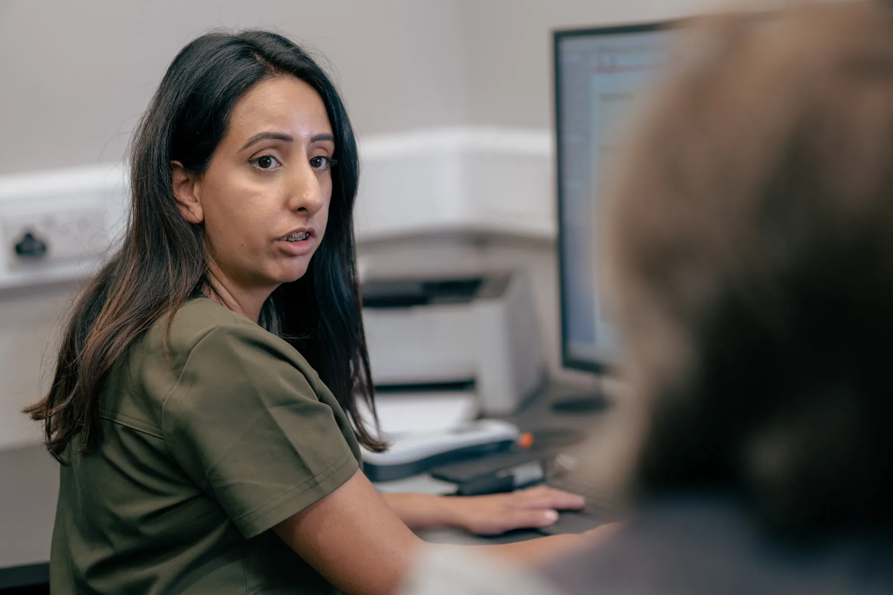 Alto audiologist discussing hearing care with a patient in clinic