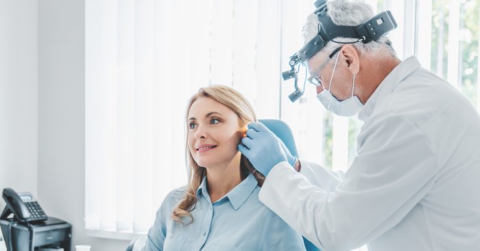 ENT doctor using loupes to examine ear