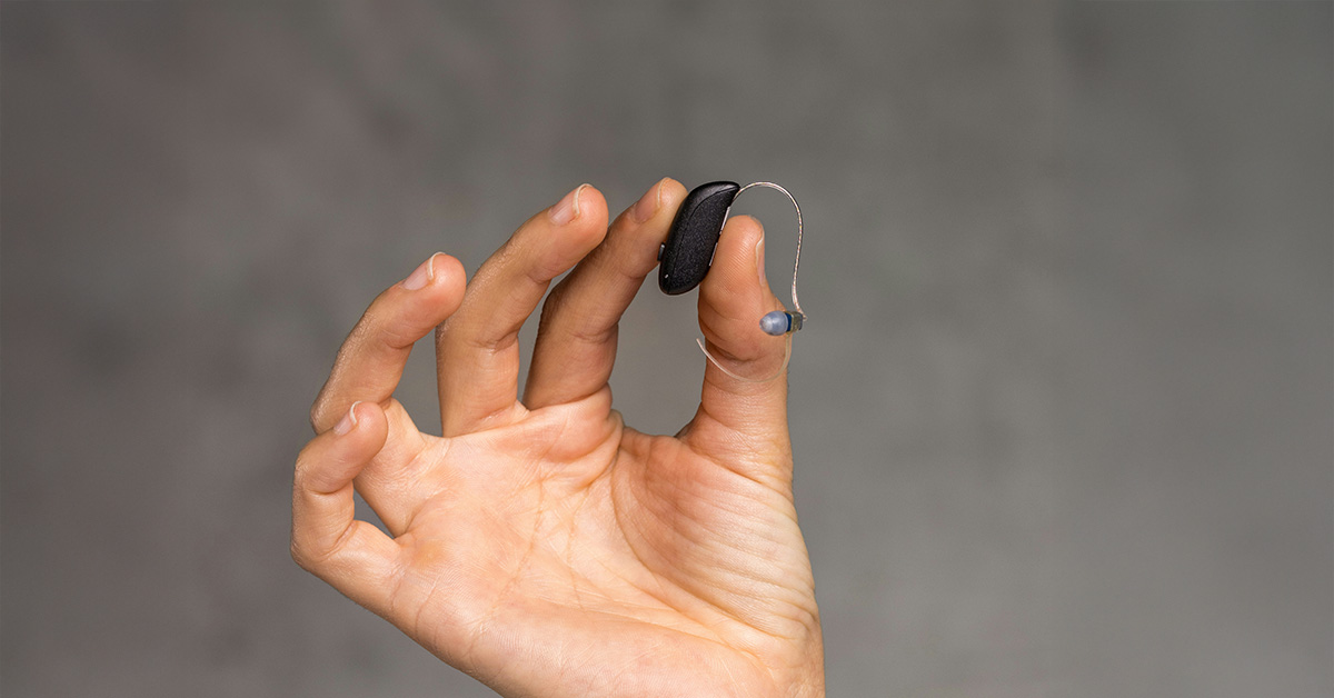 Hearing aid adjustment period: A Resound Vivia hearing aid being held up in the air