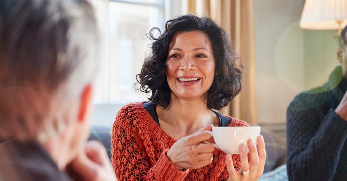 Woman having a conversation, drinking coffee
