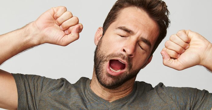 Man yawning after dealing with speech in background noise all day