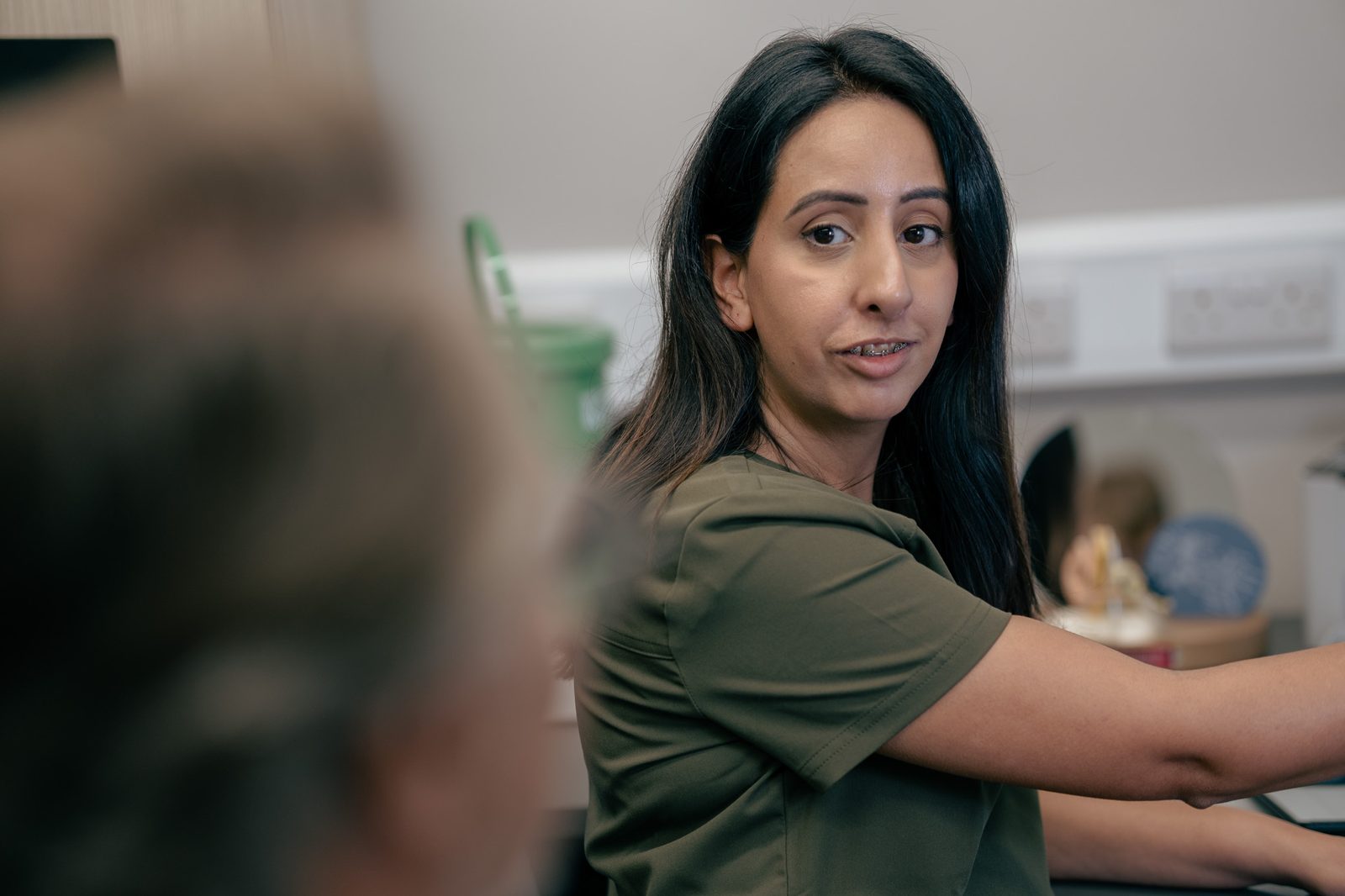 Alto audiologist speaking with a client during a hearing aid aftercare appointment