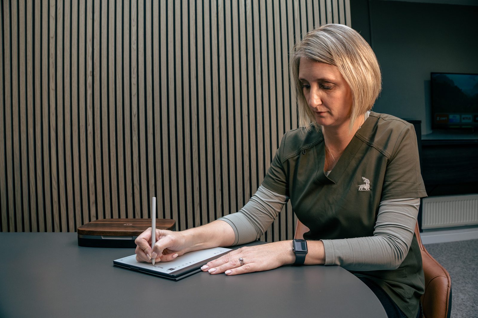 Alto audiologist making notes during a hearing aid follow-up appointment