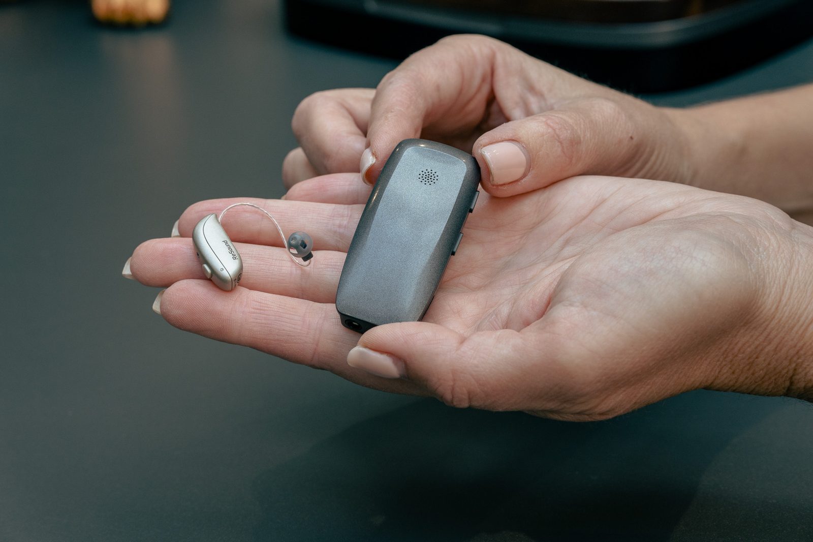 Audiologist holding hearing aids during an Alto Hearing appointment