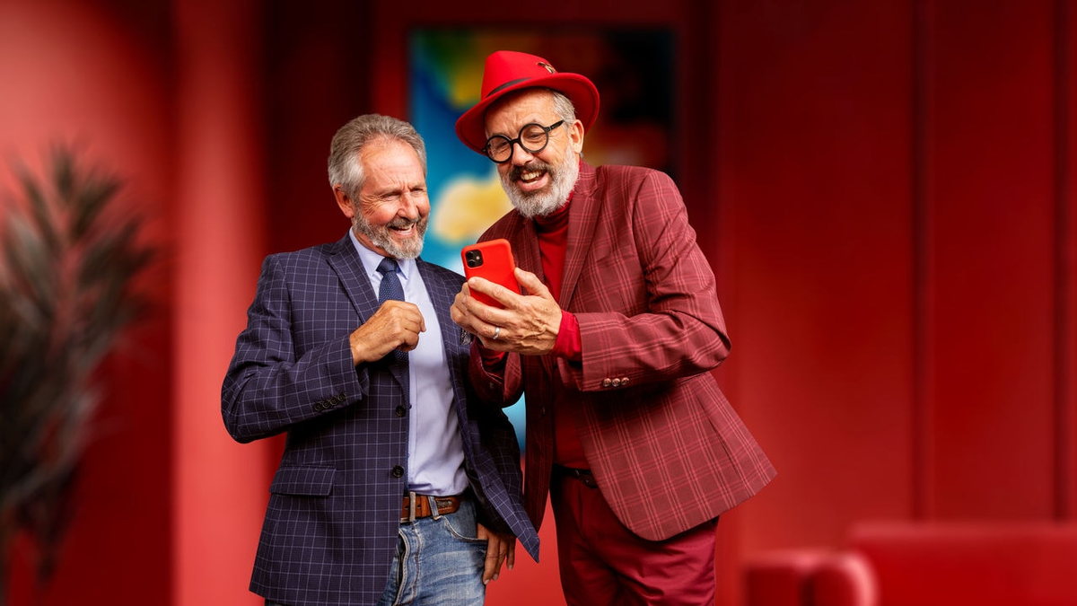 Two people using a smartphone in a Unitron Smile lifestyle image