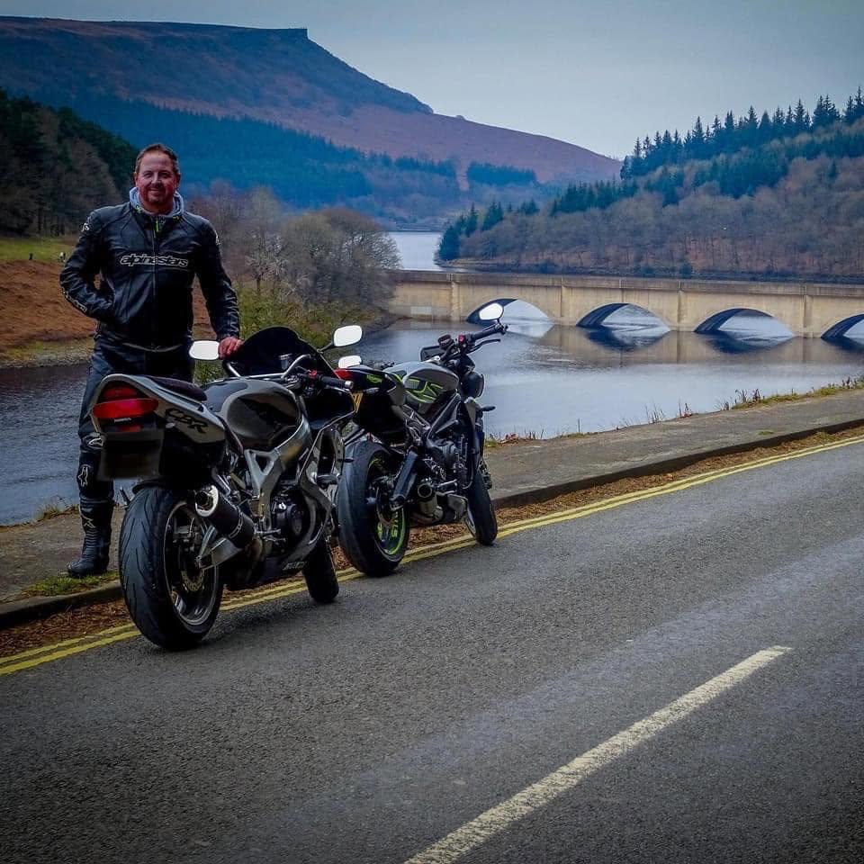 Carl Morley standing beside motorcycles during a ride