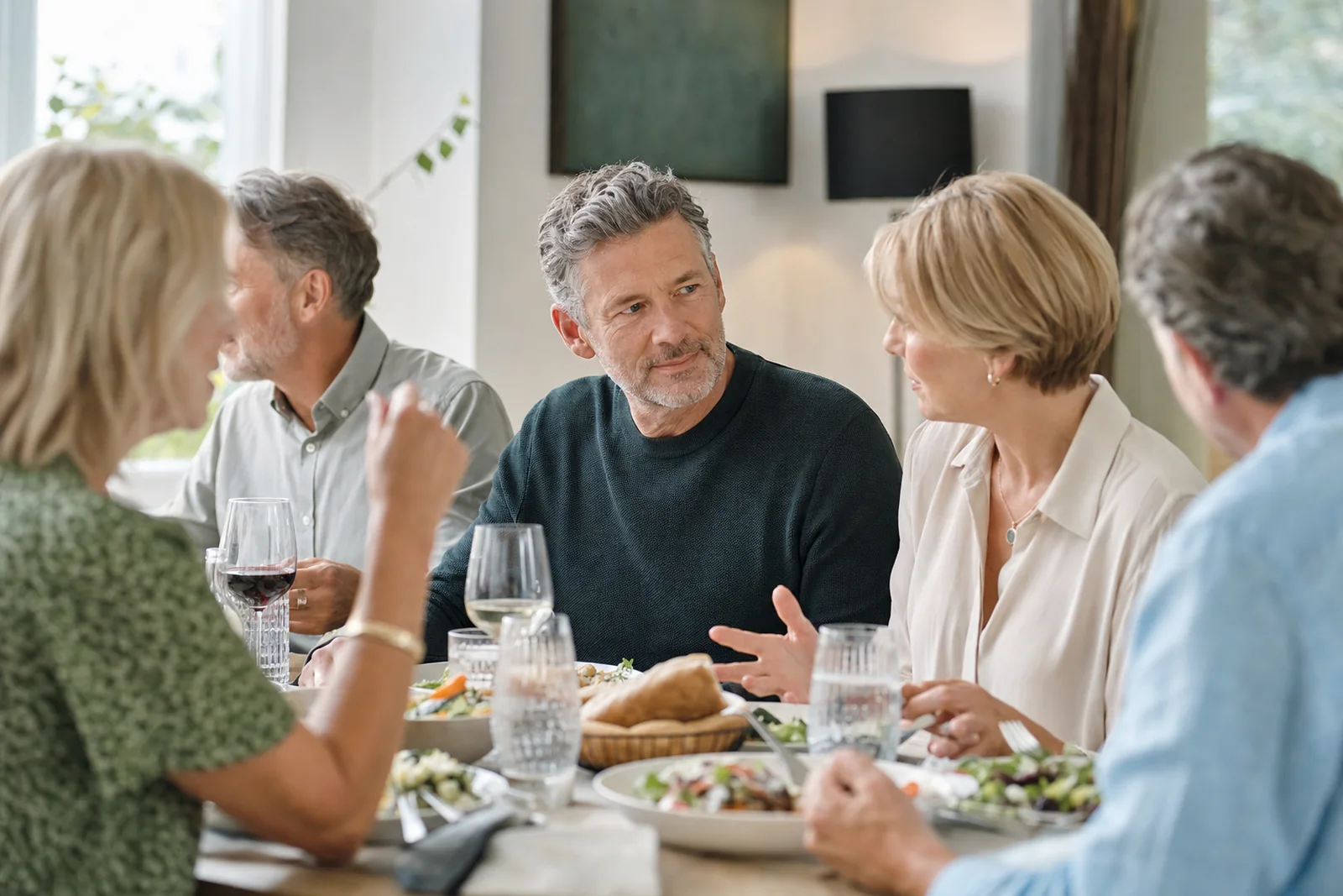 Adults having overlapping conversations around a restaurant table