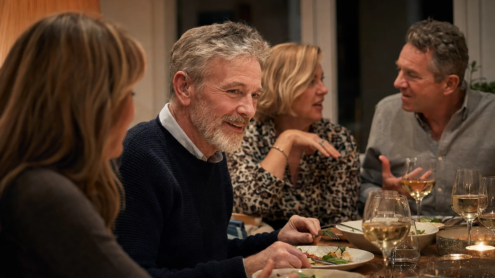 Man following a family conversation while wearing a modern hearing aid