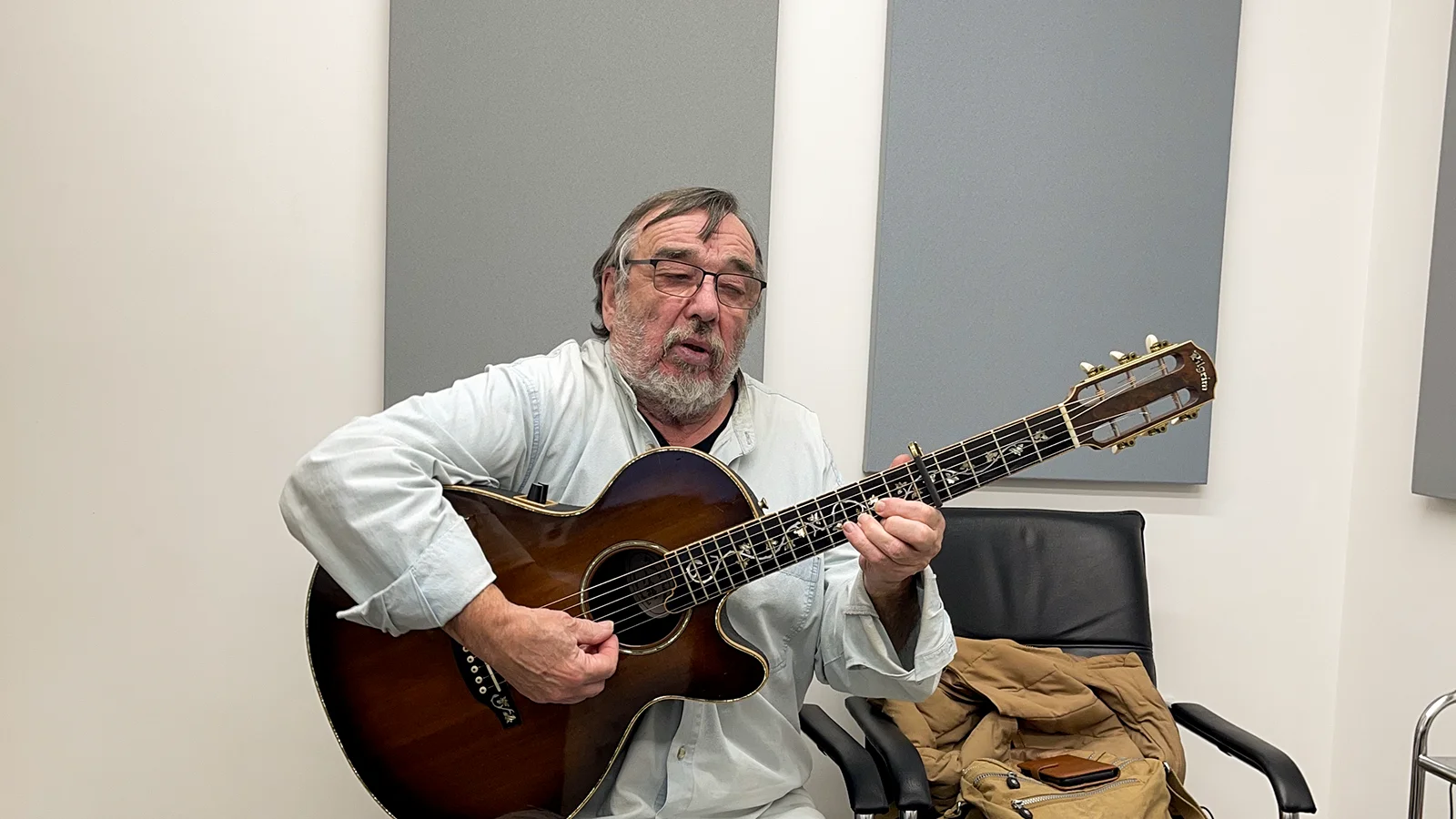 Musician playing an acoustic guitar during an appointment at Alto Hearing