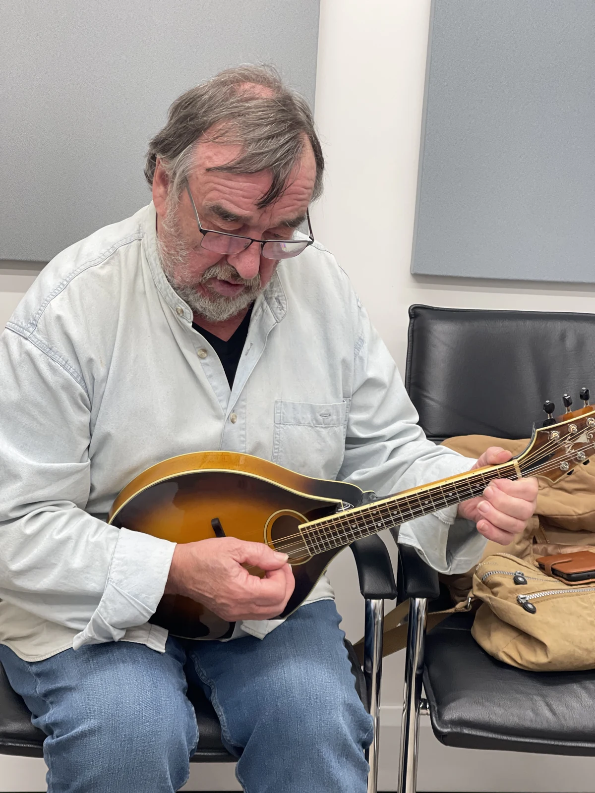 Musician playing a mandolin at Alto during a hearing-aid fitting appointment