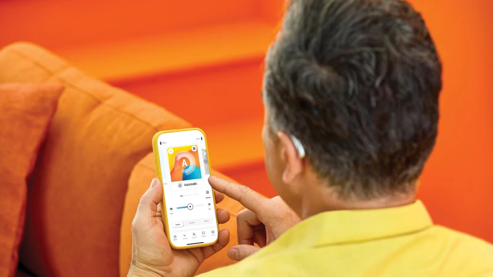 Hearing-aid wearer using the Unitron Remote Plus app on his phone